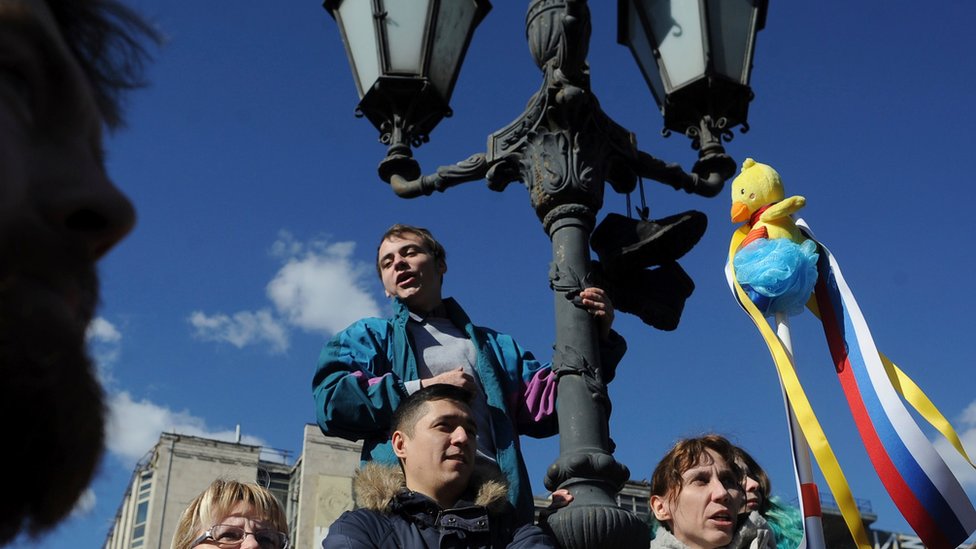 Женщина держит желтую утку во время акций протеста в Москве 26.03.2017