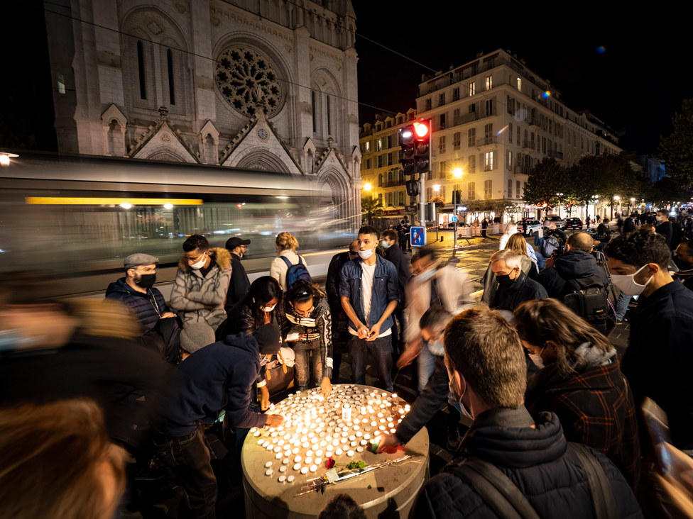 إضاءة شموع أمام كنيسة نوتردام في مدينة نيس الفرنسية تأبينا لثلاثة أشخاص قتلوا داخل الكنيسة، في اعتداء وصفه الرئيس الفرنسي إيمانويل ماكرون بأنه "هجوم إرهابي إسلامي".