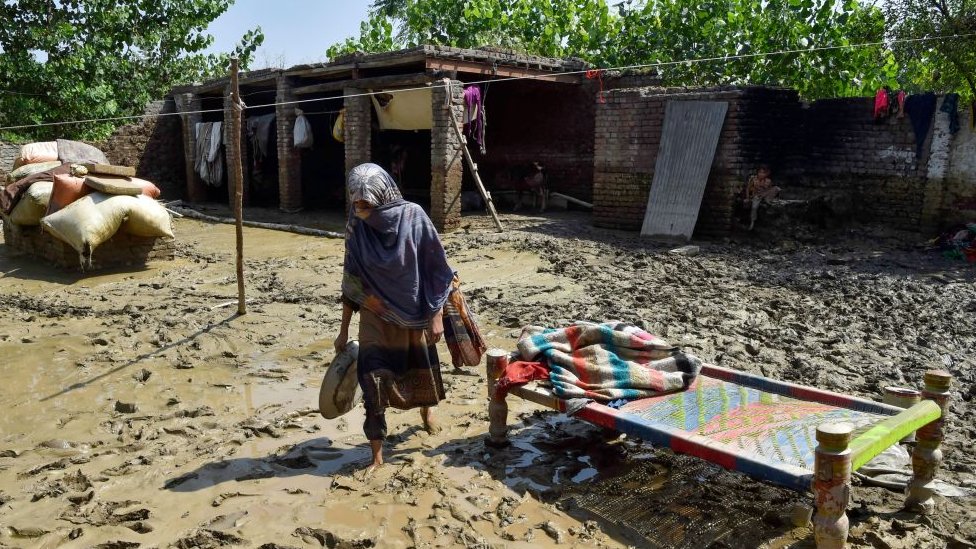 Una mujer afectada por las inundaciones camina fuera de su casa dañada en la aldea de Jindi en el distrito de Charsadda de Khyber Pakhtunkhwa el 1 de septiembre de 2022.