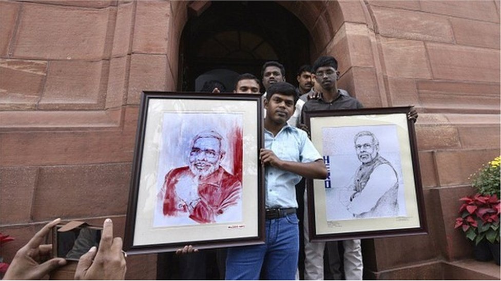 أنصار رئيس الوزراء ناريندرا مودي يحملون لوحات له مرسومة بالدم