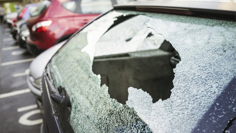 Разбитое стекло / разбитое лобовое стекло автомобиля после взлома автомобиля.