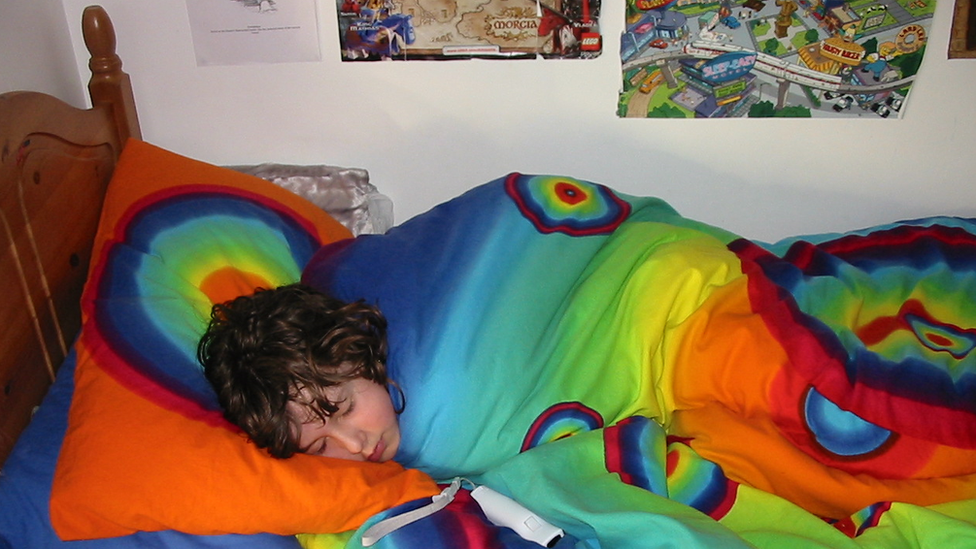 Menino dormindo com cobertor colorido