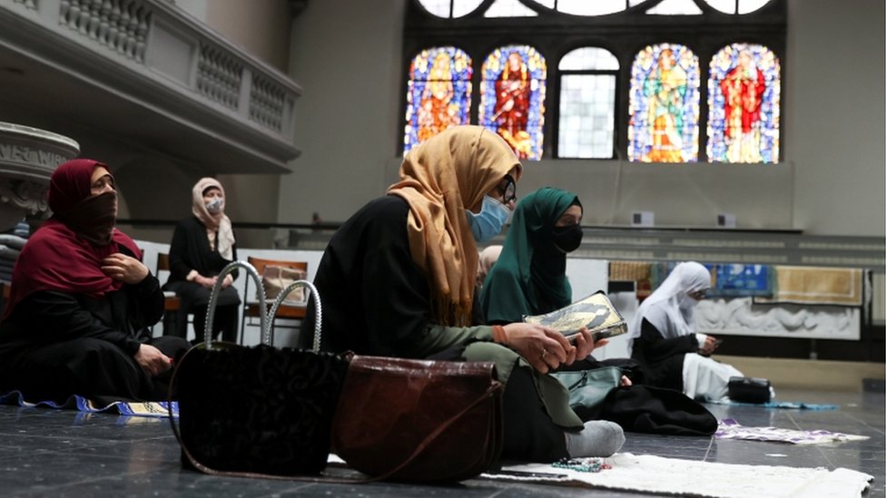 Women wearing headscarves and face masks attend Friday prayers at a Berlin church