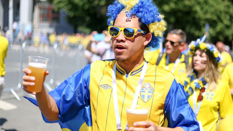 Sweden football fan holding two pints of beer