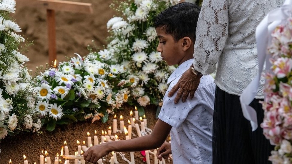 A young boy lights a candle at a grave after a funeral for a person killed in the Easter Sunday attack on St Sebastian"s Church, on April 25, 2019 in Negombo, Sri Lanka.