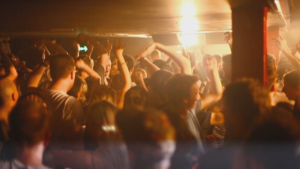 Люди танцуют в переполненном ночном клубе