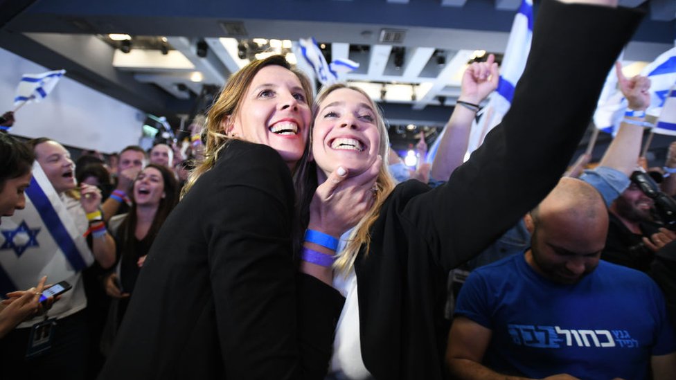 Partidarios de la coalición Azul y Blanco celebran los resultados de las encuestas de boca de urna.