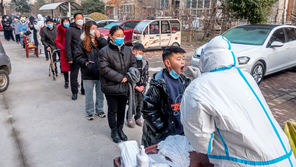 Personas en fila para hacerle la prueba de PCR en China.