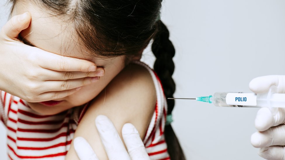 Una niña siendo vacunada contra la polio