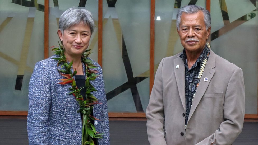 Penny Wong smiles beside Henry Puna, the Secretary General of the Pacific Island Forum
