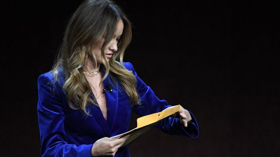 Olivia Wilde abriendo un sobre en un teatro de Las Vegas.