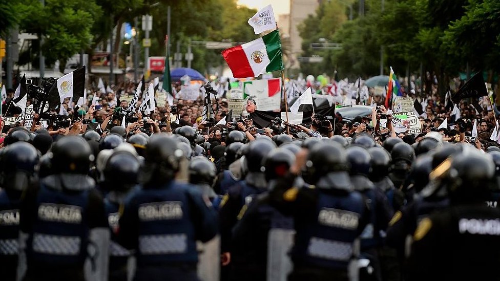 Протестующие сталкиваются с линией ОМОНа в Мехико