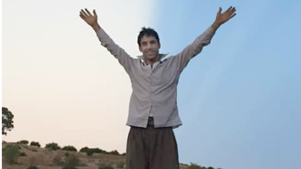Vahid Afkari standing on the roof of a car with his arms in the air