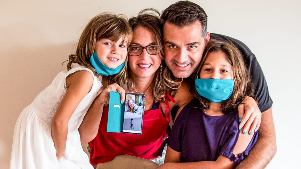 Camila, o marido e as filhas durante videochamada com os pais dela em 27 de março