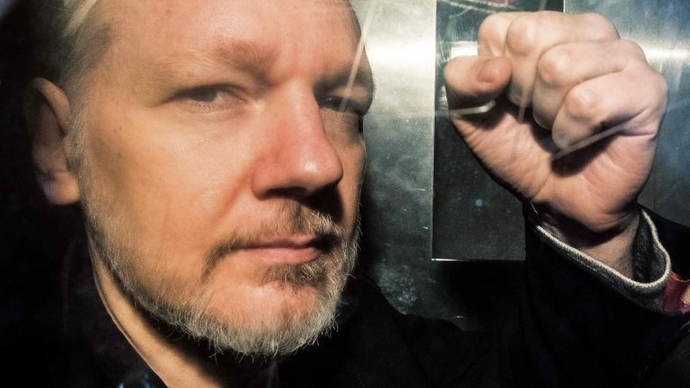Julian Assange, fundador de WikiLeaks levantando el puño izquierdo.