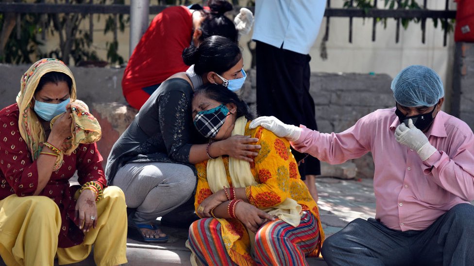 Parentes enlutados e familiares de vítimas de Covid esperam do lado de fora do necrotério da Maulana Azad Medical College para recolher seus corpos, em 25 de abril de 2021 em Nova Delhi, Índia