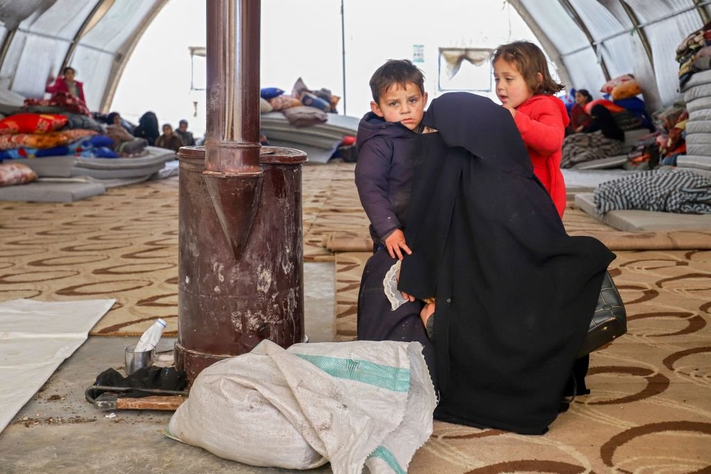 Una mujer y sus dos hijos en un campamento de refugiados en el norte de Siria