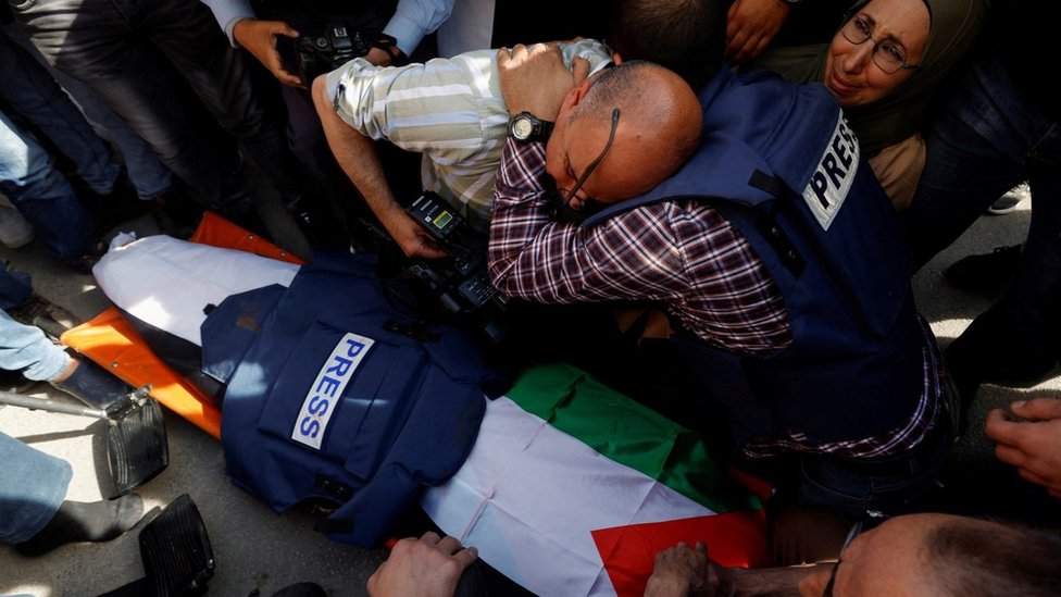 Novinari pored tela dopisnice Al Džazire Šerine Abu Akle, koja je ubijena tokom izraelske racije u okupiranom gradu Dženin na Zapadnoj obali (11. maj 2022.)