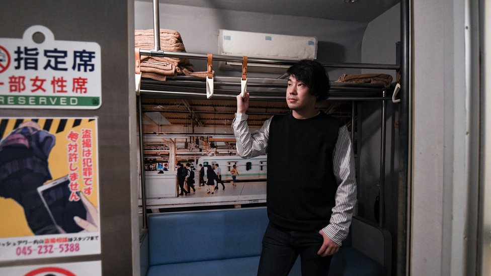 「尖峰時刻」色情俱樂部經理蓮田修平在俱樂部的一個火車車廂模型中擺拍照片