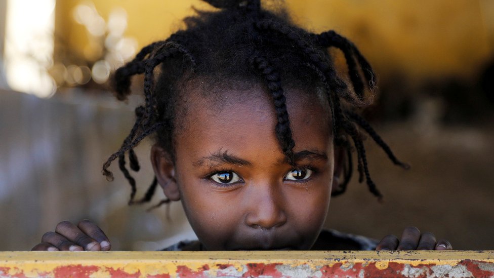 An Ethiopian girl stands at the window of a temporary shelter, at the Village 8 refugees' transit camp, which houses Ethiopian refugees fleeing the fighting in the Tigray region, near the Sudan-Ethiopia border, Sudan, December 2, 2020