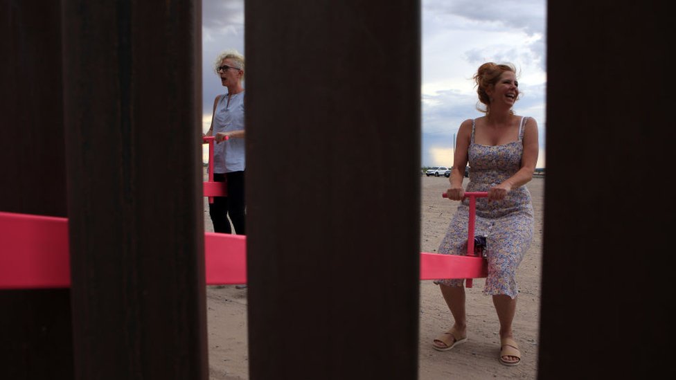 A woman plays on the installation on the Mexican border with the US