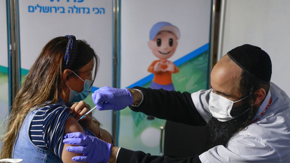 سيدة تتلقى لقاحا في القدس.