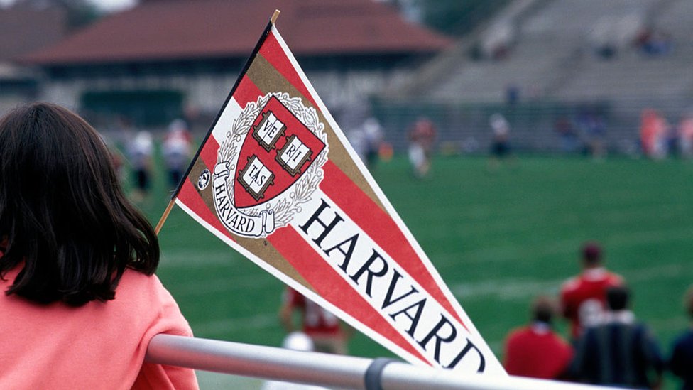 Una estudiante porta una banderola en la que puede leerse "Harvard"