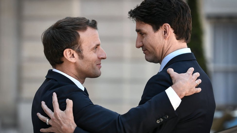 Emmanuel Macron bids farewell to Canadian Prime Minister Justin Trudeau as he leaves the Elysee presidential Palace