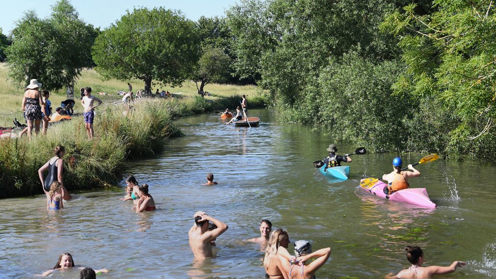 Люди играют в реке Кэм в Грантчестере недалеко от Кембриджа