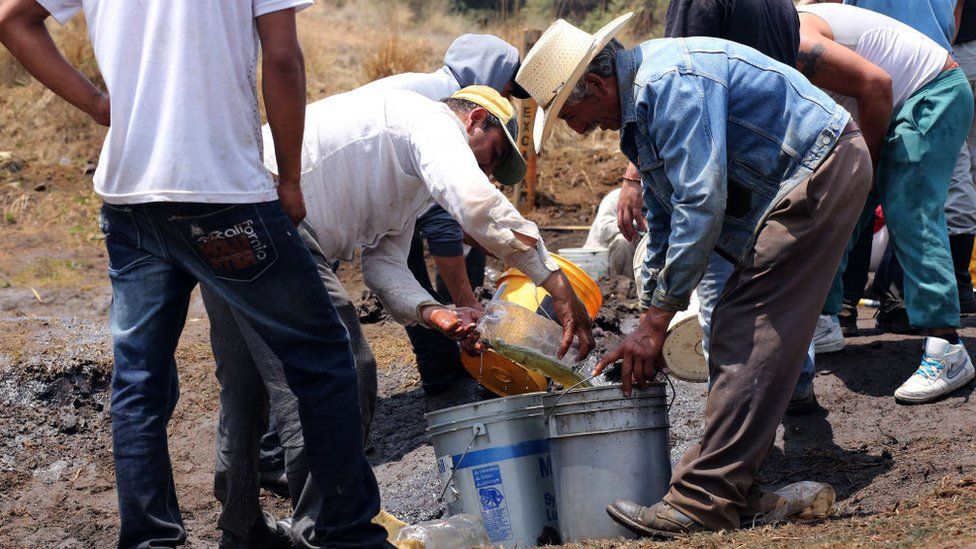 Hombres en México extrayendo combustible.