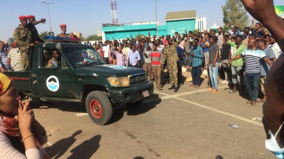 مركبة للجيش تمر بين المعتصمين قرب مقر قيادة الجيش في الخرطوم