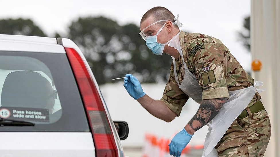 Солдат помогает проводить тестирование COVID-19 для ключевых сотрудников NHS на полигоне в Плимуте