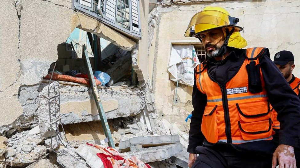 Trabajador de rescate en la escena de un ataque aéreo israelí en la Franja de Gaza