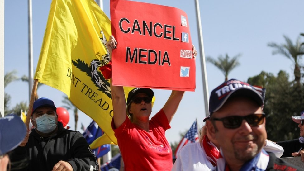 A Trump supporter holds a sign in front of the Arizona State Capitol in Phoenix, Arizona