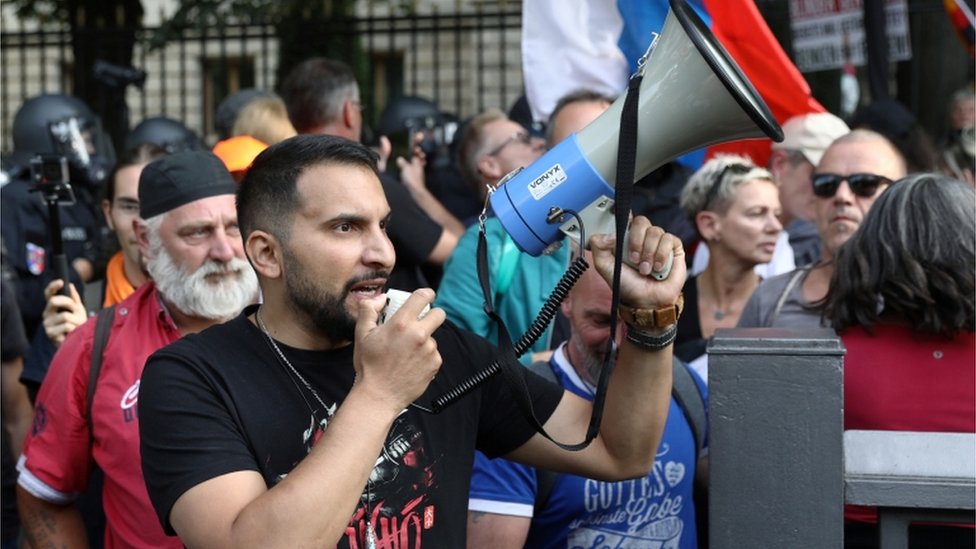 Attila Hildmann speaks through the megaphone during a rally against the government's restrictions following the coronavirus disease (COVID-19) outbreak, in Berlin