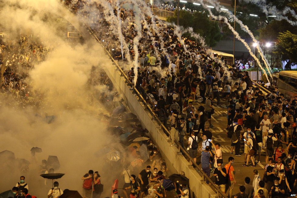 Полиция применила слезоточивый газ против демонстрантов, выступающих за демократию, возле штаб-квартиры правительства Гонконга 28 сентября 2014 года.