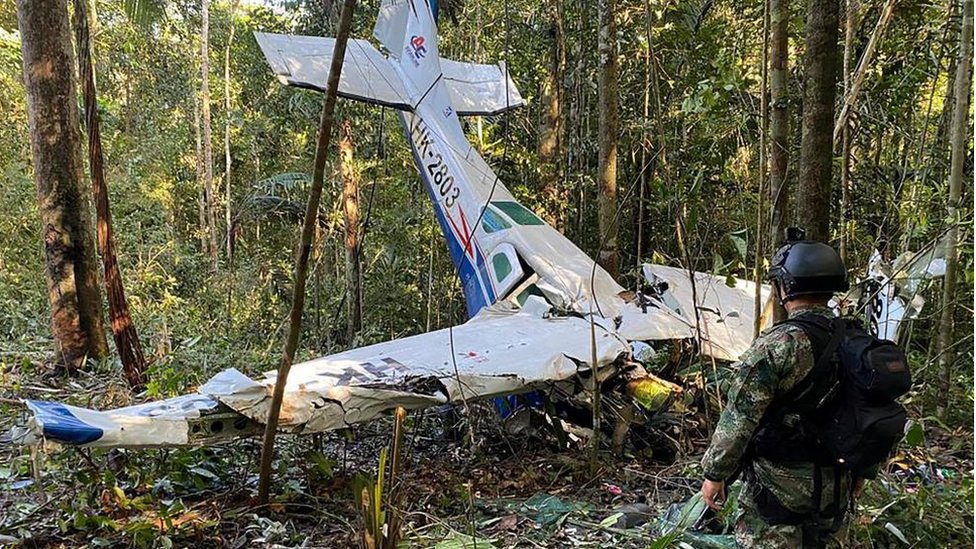 A soldier stands next to the wreckage of the plane during a search for the children on 19 May