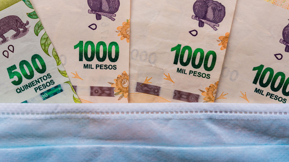 Billetes de 500 y 1000 pesos detrás de una mascarilla