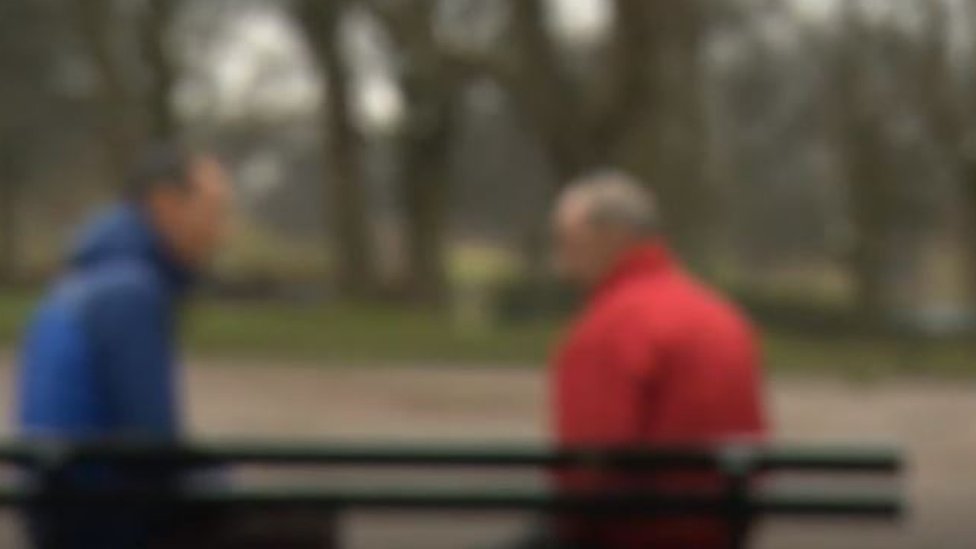 El hombre vestido de rojo es un ciudadano polaco que fue víctima de trata en el sector de la agricultura en Inglaterra. "Todo era trabajo, trabajo, nada de dinero (...) Me sentí un prisionero", le contó a un reportero de la BBC. Dos hombres hablando