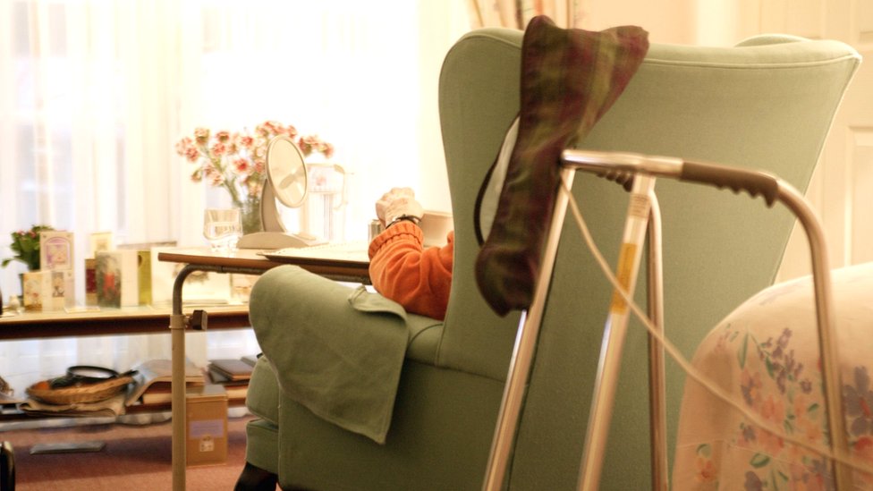 Человек, сидящий в кресле в доме престарелых