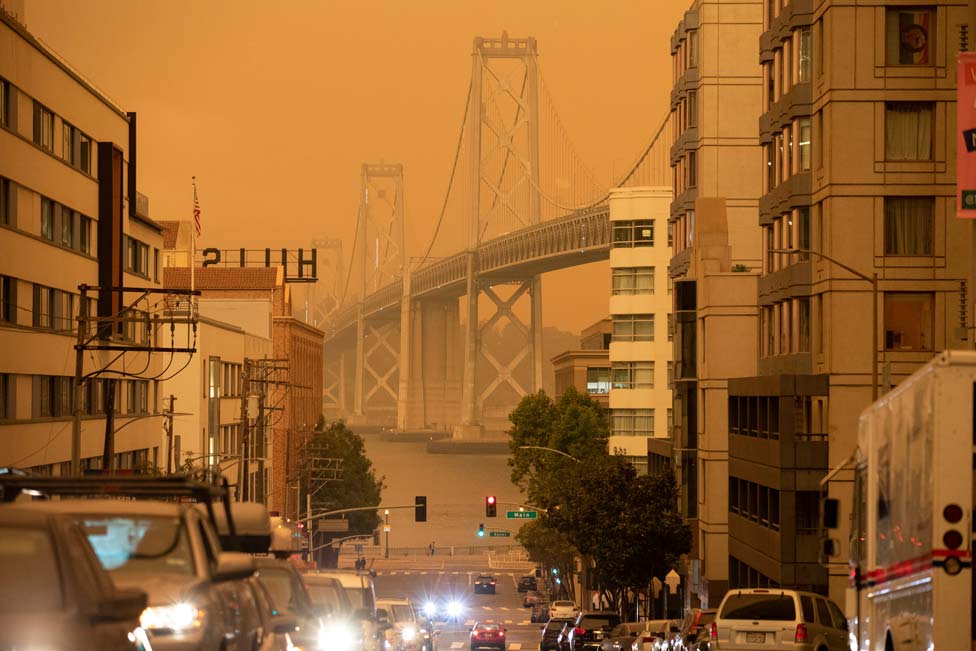 The Bay Bridge is seen under an orange sky darkened by the smoke from California wildfires in San Francisco