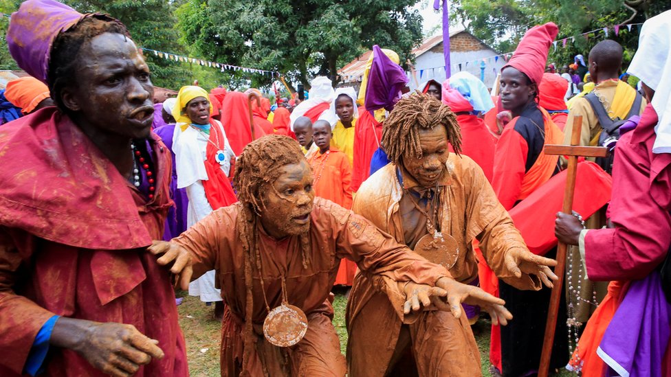 Men cover themselves in mud to attend a Christmas Day procession near Ugunja, in Siaya County, Kenya