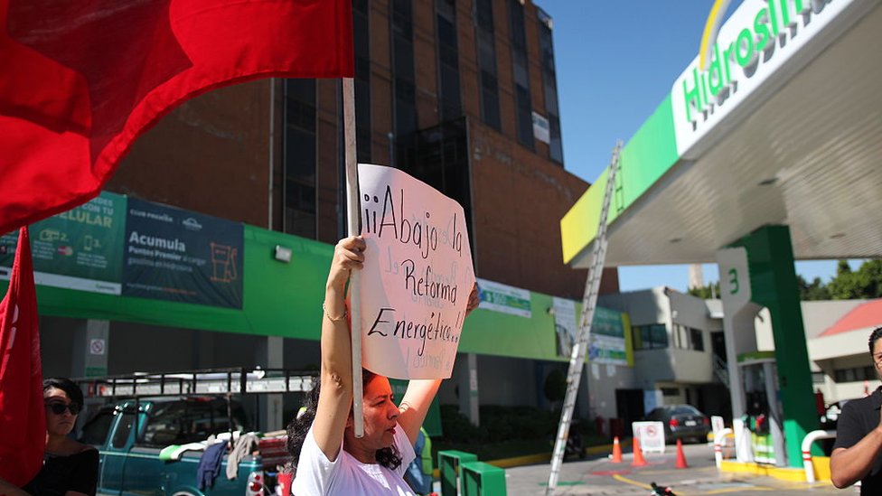 Una mujer sostiene un cartel contra la reforma energética.