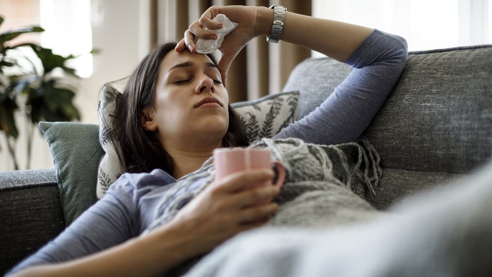 mulher doente deitada no sofá