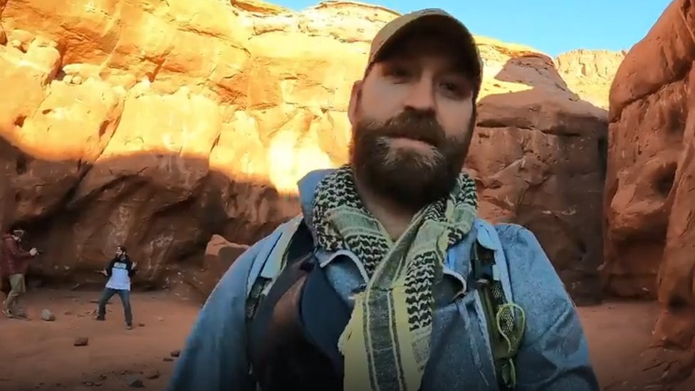 David Surber filming himself inside the canyon near the monolith