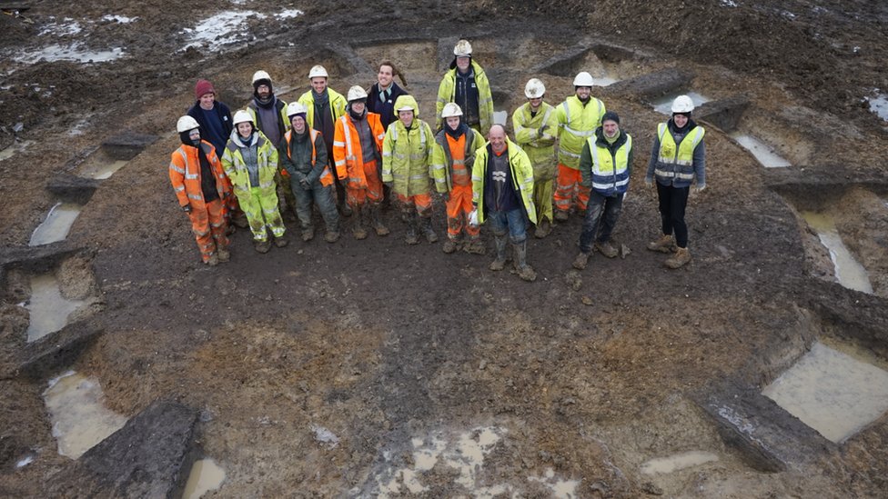 Археологи стоят в рубке на раскопках Warboys