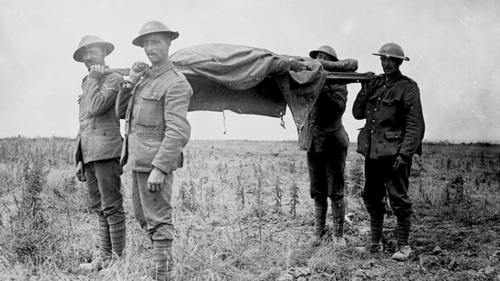 Войска союзников несут на носилках мертвого солдата во время битвы на Сомме в Первой мировой войне