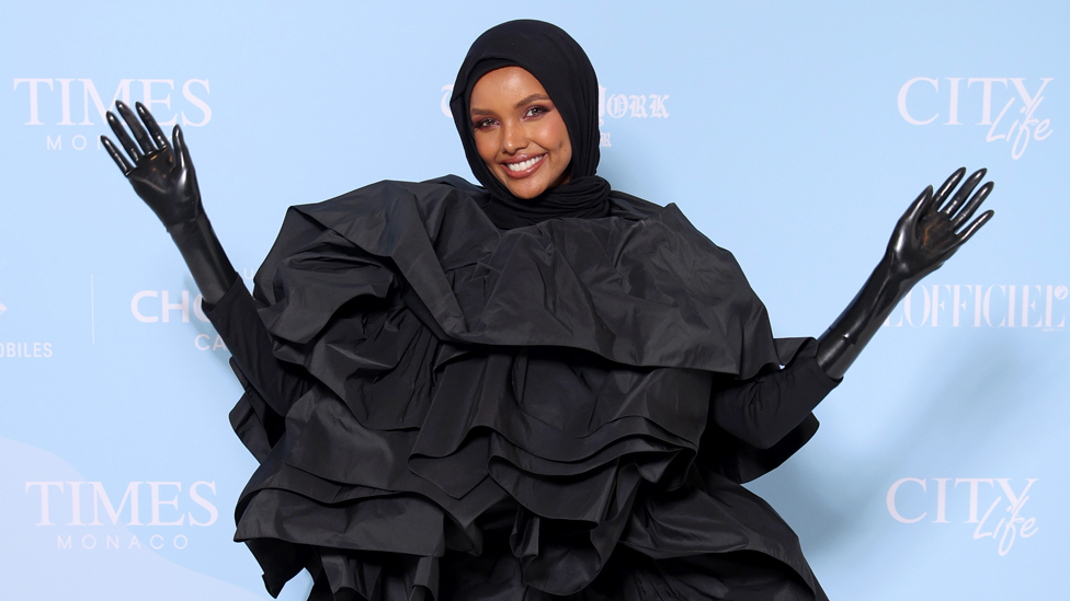 عارضة الأزياء الصومالية الأمريكية حليمة عدن تلوح في حفل توزيع جوائز المؤثرين والمدونين العالميين في كان، فرنسا - الجمعة 26 مايو/ أيار 2023