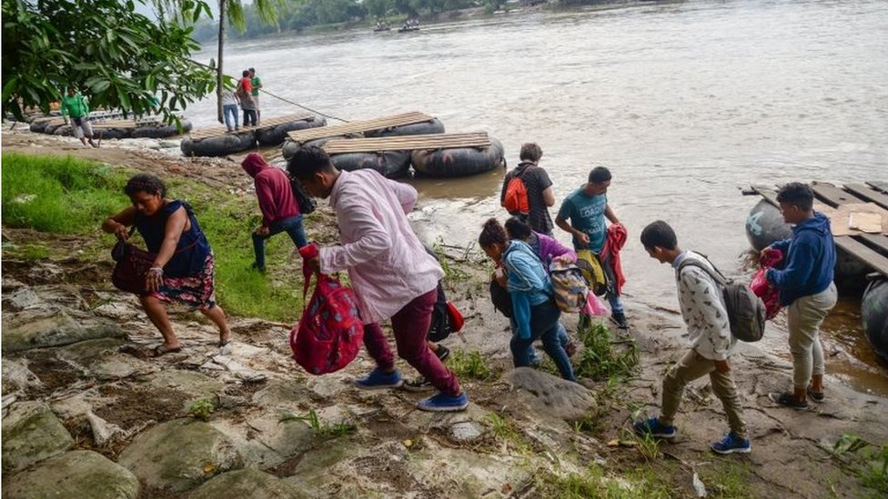 Мигранты пересекают реку Сухиате, которая ограничивает границу между Гватемалой и Мексикой, в штате Чьяпас, Мексика, 11 июня 2019 года. T