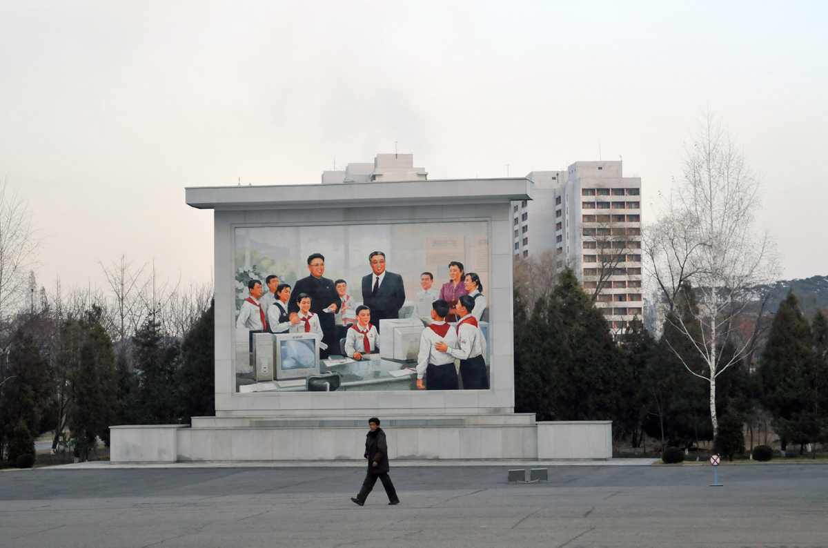 A mural depicts Kim Il-sung and Kim Jong-il in a school IT class